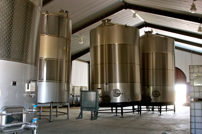 Large stainless steel wine fermentation tanks in a winery facility in Lodi, California.