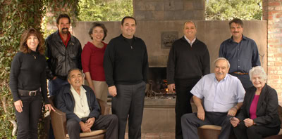 Group photo of Lodi Winegrape Commission members outdoors near a fireplace.