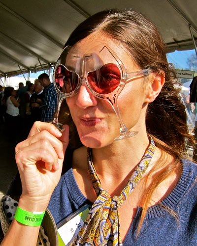 Woman tasting wine at Lodi Winegrape Commission event, wearing sunglasses and a colorful scarf.