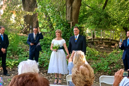 Wedding ceremony outdoors with the Lodi Winegrape Commission logo in the background.