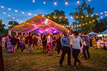 People dancing and enjoying a festival under string lights at an outdoor event in Lodi, California.