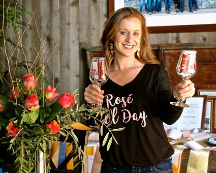 Woman holding two glasses of rosé wine at Lodi Winegrape Commission event.