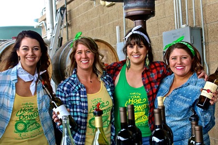 Group of women celebrating with wine bottles at Lodi Winegrape Commission event.
