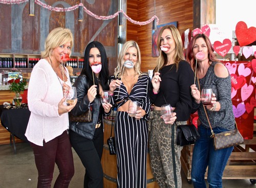 Group of women celebrating Valentine's Day with wine and heart-themed decorations at Lodi Winegrape Commission.