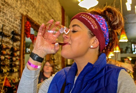 Woman enjoying wine tasting at Lodi Winegrape Commission event, showcasing local wine culture and vineyards.