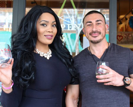 Two people holding wine glasses at a Lodi Winegrape Commission event, smiling and enjoying wine tasting.