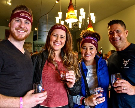 Group of four smiling people enjoying wine at a Lodi Winegrape Commission event.