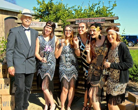 Group of women and man at Lodi Winegrape Commission event, smiling and enjoying outdoor celebration.