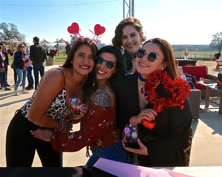 Group of women celebrating at Lodi Winegrape Commission event with festive accessories and wine glasses.