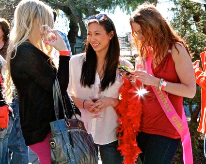 Three women at a Lodi Winegrape Commission event enjoying conversation and wine tasting outdoors.