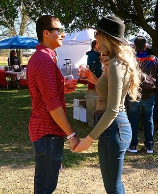 Couple holding hands and enjoying wine tasting at Lodi Winegrape Commission event.
