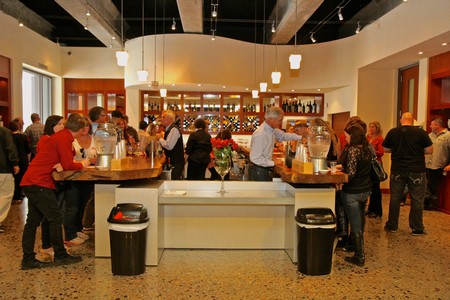 People enjoying wine tasting at Lodi Winegrape Commission event in a modern venue.