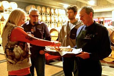 Group of people enjoying wine tasting at Lodi Winegrape Commission event in a winery setting.