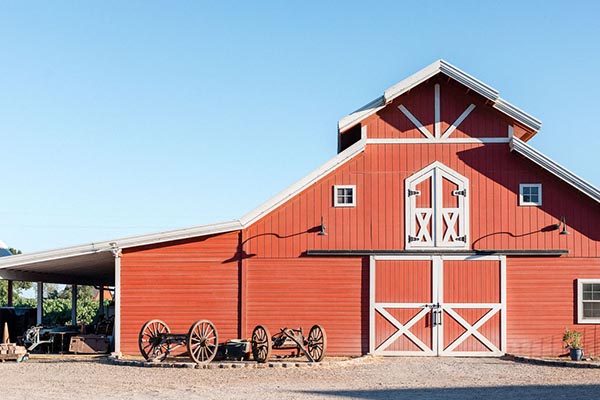 Red barn with white accents and wagons in front, representing Lodi wine industry.