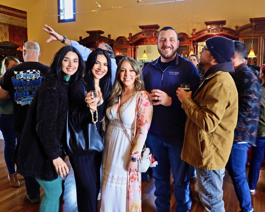 Group of people enjoying wine tasting at Lodi Winegrape Commission event.