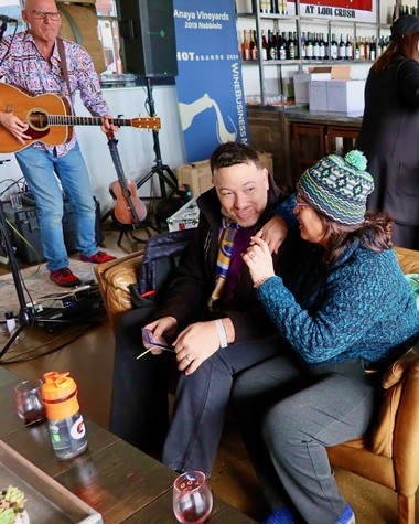 People enjoying wine tasting at a Lodi Winegrape Commission event with live music and socializing.