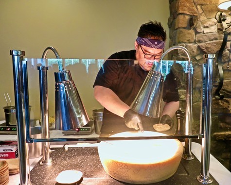 Chef preparing cheese with wine in a professional kitchen setting for Lodi Winegrape Commission.