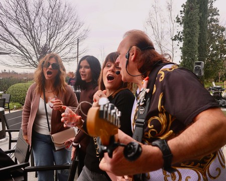 Group of people enjoying live music and wine outdoors at a Lodi Winegrape Commission event.