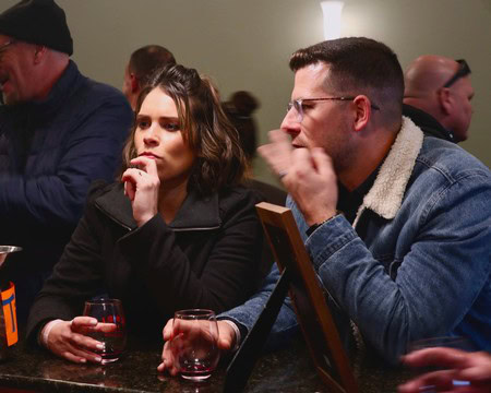 People tasting wine at a Lodi Winegrape Commission event, enjoying wine and conversation.
