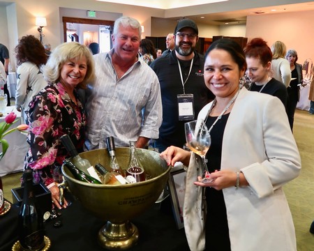 Group of people enjoying wine tasting at Lodi Winegrape Commission event in a lively setting.