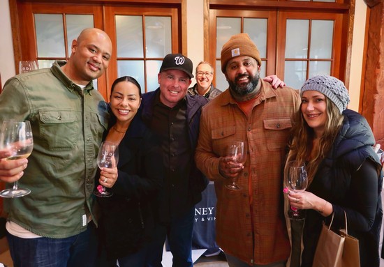Group of diverse people enjoying wine tasting at Lodi Winegrape Commission event.