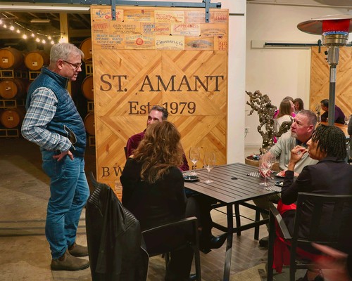 Group of people at a wine tasting event with Lodi Winegrape Commission banner in the background.