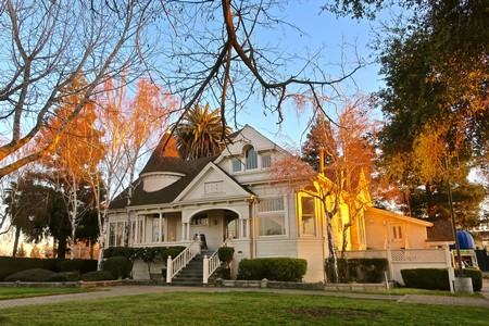Elegant Victorian house surrounded by trees with autumn foliage in Lodi, California.