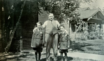 Black and white photo of a man with two children outdoors in Lodi, California.