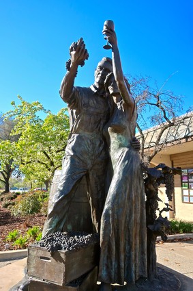 Bronze statue of a man and woman holding a wine glass, symbolizing wine culture in Lodi, California.