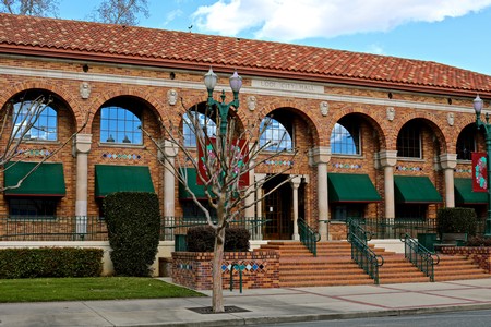 Historic brick building of the Lodi Winegrape Commission with arched windows and green awnings in Lodi, California.
