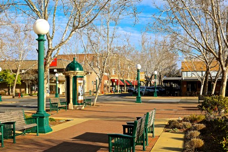 Scenic view of a town square with benches, lamp posts, and leafless trees in Lodi, California.