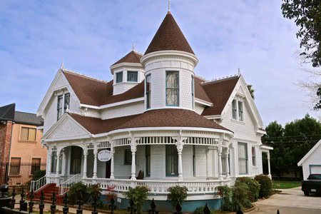 Elegant Victorian house with intricate woodwork and a turret in Lodi, California.