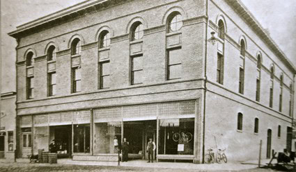 Black and white photo of the historic Lodi Winegrape Commission building with large windows and vintage storefronts.