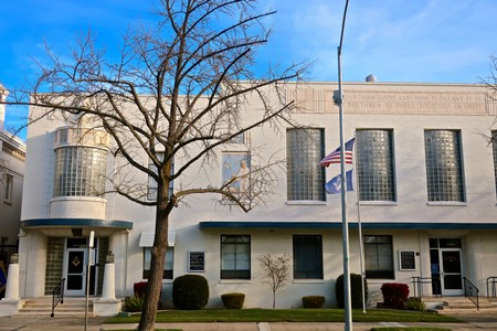 Exterior view of the Lodi Winegrape Commission building with a tree and American flag in front.