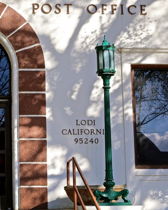 Historic Lodi Post Office with green lamp post and arched window in California.