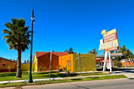 Colorful Rancho Grande Motel with palm trees and clear blue sky in Lodi, California.