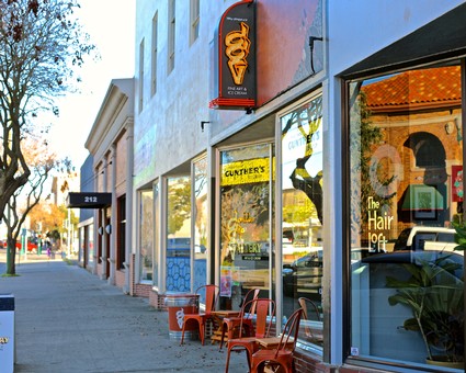 Exterior view of the Lodi Winegrape Commission office with storefronts and outdoor seating in Lodi, California.