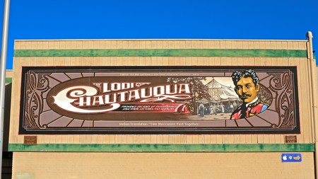Large outdoor sign for Lodi Winegrape Commission with traditional design and logo on a brick building.