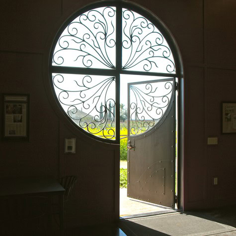 Decorative wrought iron window and open door at Lodi Winegrape Commission building.