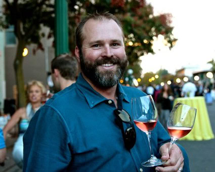 Man enjoying wine tasting at Lodi Winegrape Commission event with glasses of rosé wine.