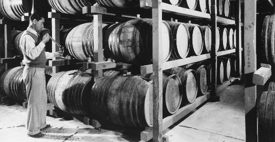 Vintage wine barrels stored on racks at Lodi Winegrape Commission facility.