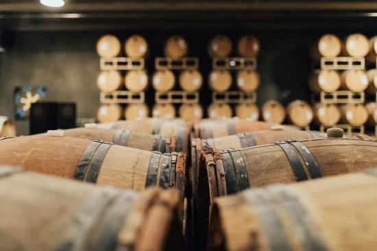 Wine barrels stored in a cellar at Lodi Winegrape Commission for aging and fermentation.