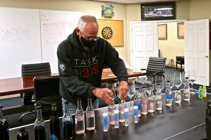 Man conducting a wine tasting with various wine bottles on a table at Lodi Winegrape Commission.