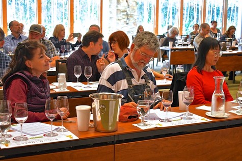 Attendees at a wine tasting event organized by the Lodi Winegrape Commission, sampling wines in a scenic outdoor setting.