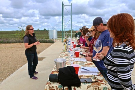 Group of people participating in a wine tasting event outdoors at Lodi Winegrape Commission.