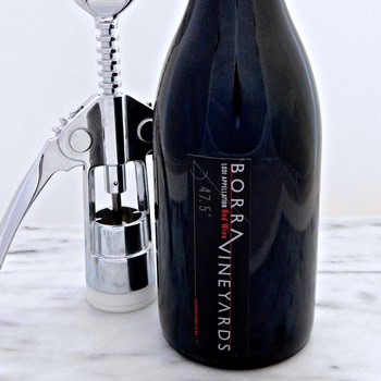 Borra Vineyards sparkling wine bottle with corkscrew on a white marble surface.