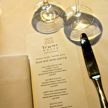 Wine glasses and menu from Lodi Winegrape Commission restaurant showcasing food and wine pairing.