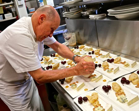 Chef decorating cheese plates with grapes and crackers for Lodi Winegrape Commission event.