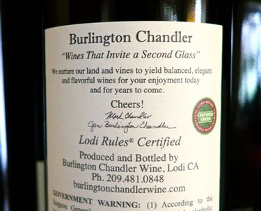 Close-up of Burlington Chandler wine label with certification and contact details.