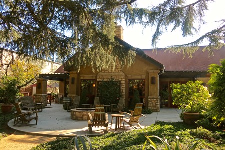 Scenic view of a vineyard with a stone building and outdoor seating area in Lodi, California.